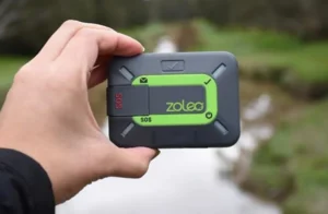 A Zoleo satellite communicator being held for outdoor tech lab 2025 testing